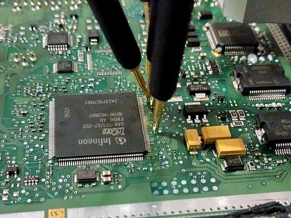 Probe pins set on the processor of an opened DME during a clone